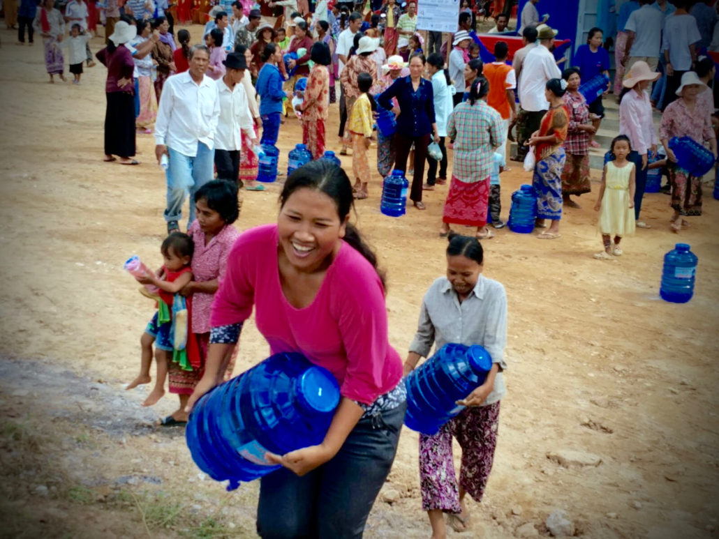 A villager carrying a new bottle of clean water purchased at the CWE handover event in Kdul Village, Cambodia. 